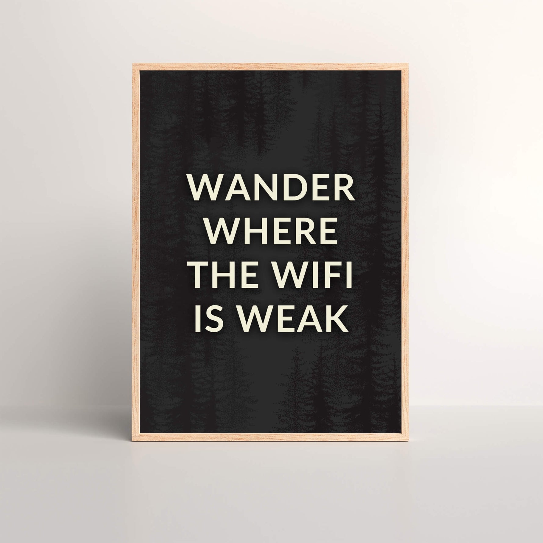 a wall art print with the saying 'Wander Where The Wifi is Weak' in a oak picture frame with black and white text
