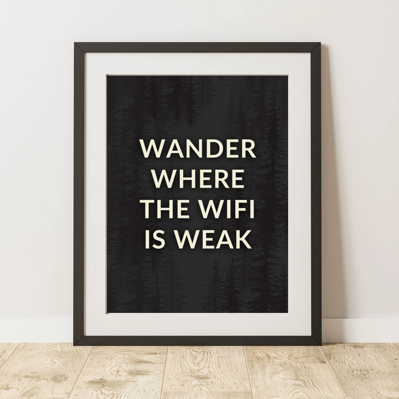 Wander Where the Wifi is Weak Fine Art Print in a black picture frame leaning against a wall and sitting on a oak wood floor